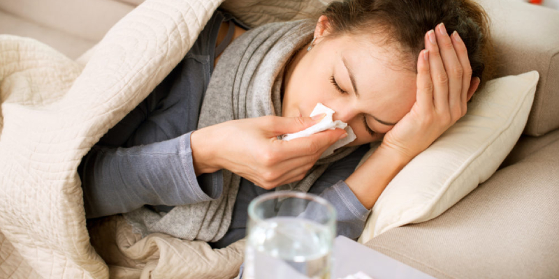 Sick woman with cold lying on a bed.